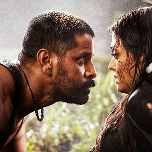 Raavanan Intense Close-Up: Bearded Man and Woman in Rainy Confrontation HD phone wallpaper