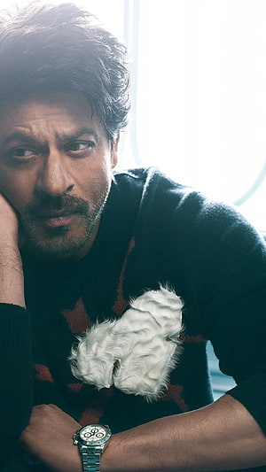Shah Rukh Khan in a dark sweater holding a small white dog with a wristwatch HD phone wallpaper