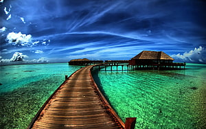 Tropical Overwater Bungalows Connected by a Long Wooden Boardwalk Over Turquoise Lagoon Water HD wallpaper