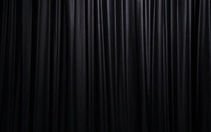Elegant Black Velvet Curtain Fabric with Deep Vertical Folds and Soft Sheen HD wallpaper