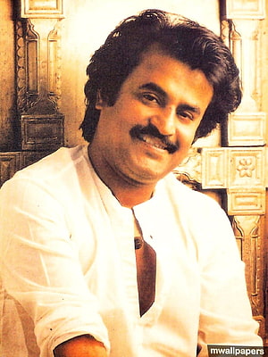 Rajinikanth smiling portrait in white kurta with ornate wooden background HD phone wallpaper