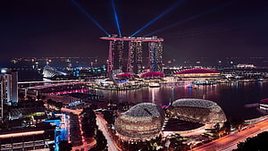 Marina Bay Sands and Singapore skyline at night with illuminated waterfront and laser beams HD wallpaper