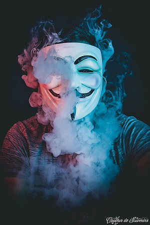 Person Wearing Guy Fawkes Mask Surrounded by Dramatic Smoke HD phone wallpaper