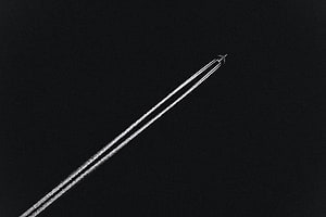 Minimalist Airplane Leaving Contrails Against a Dark Night Sky HD wallpaper