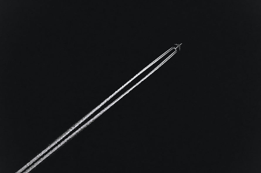 Minimalist Airplane Leaving Contrails Against a Dark Night Sky HD wallpaper