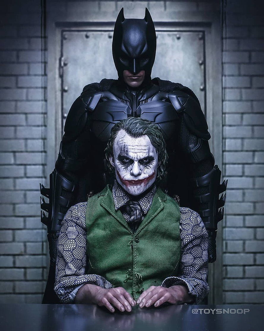 Batman and The Joker Collectible Figure Display in Dark Interrogation Room Setting HD phone wallpaper