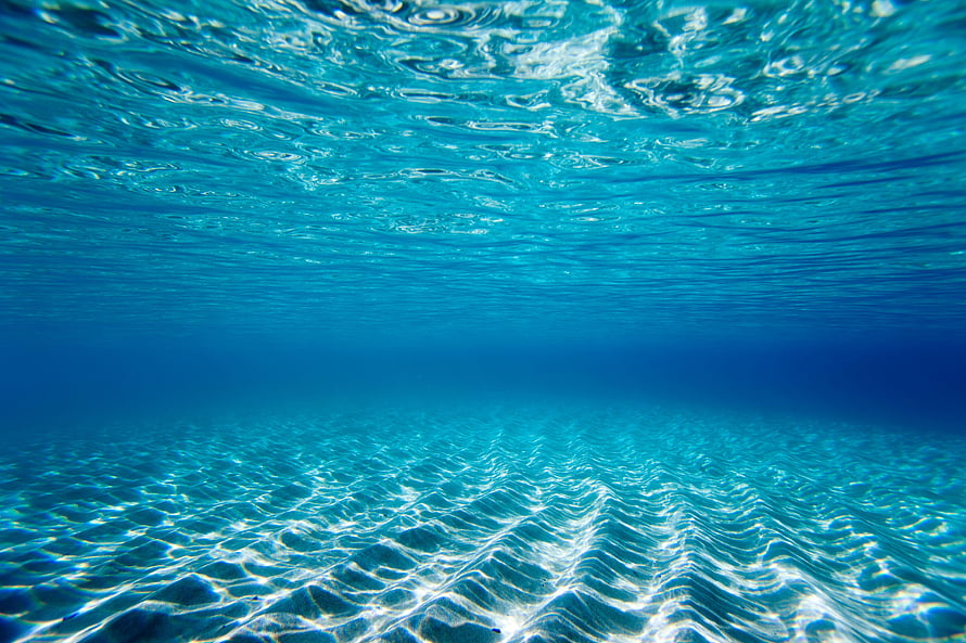 Underwater Ocean Scene With Sunlight Patterns On Sandy Seabed And Turquoise Water Surface HD wallpaper