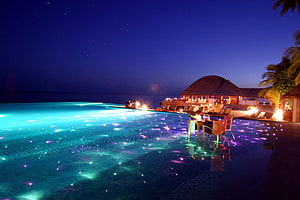 Luxury Maldives Resort Infinity Pool Glowing Under Starry Night Sky HD wallpaper