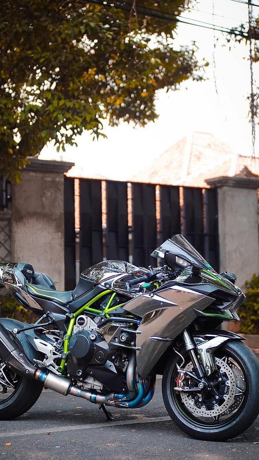 Kawasaki Ninja sport motorcycle with green frame parked on a street HD phone wallpaper