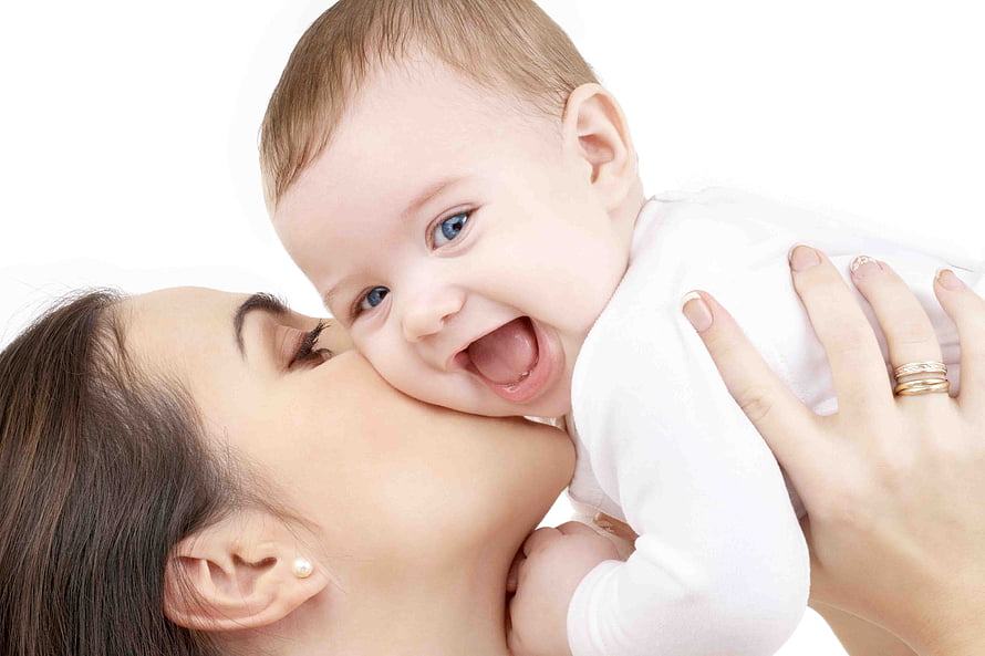Mother Kissing Her Smiling Baby On The Cheek In A Bright Studio Setting HD wallpaper