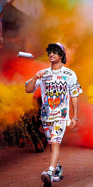 Tovino Thomas in colorful streetwear with graffiti print and vibrant smoke background HD phone wallpaper