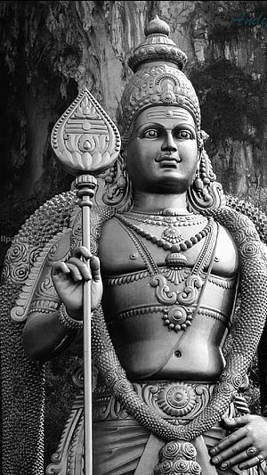 Monochrome Statue of Lord Murugan Holding a Spear in Traditional Indian Temple Style HD phone wallpaper