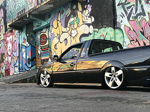 Black VW Saveiro Pickup with Stance Setup Parked Against Vibrant Graffiti Wall HD wallpaper