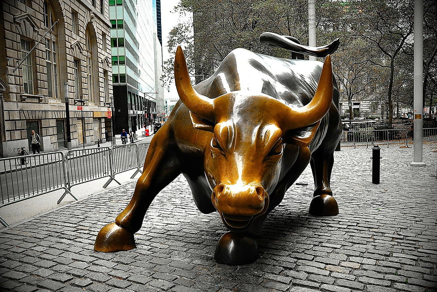 Charging Bronze Bull Statue on Cobblestone Plaza in Financial District HD wallpaper
