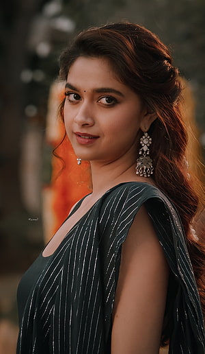 Keerthy Suresh in a dark striped sari with traditional silver jhumka earrings and soft natural lighting HD phone wallpaper