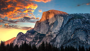 Half Dome at Sunset in Yosemite National Park with Dramatic Orange Clouds and Granite Cliffs HD wallpaper