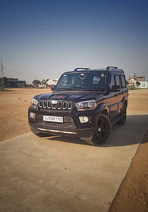 Black Mahindra Scorpio SUV Parked on Concrete Pad in Open Desert Landscape HD phone wallpaper