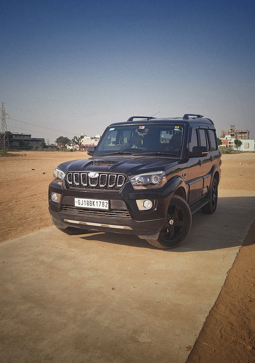 Black Mahindra Scorpio SUV Parked on Concrete Pad in Open Desert Landscape HD phone wallpaper