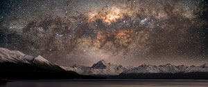 Milky Way Galaxy Arching Over Snow-Capped Mountain Range at Night HD wallpaper