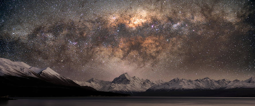 Milky Way Galaxy Arching Over Snow-Capped Mountain Range at Night HD wallpaper