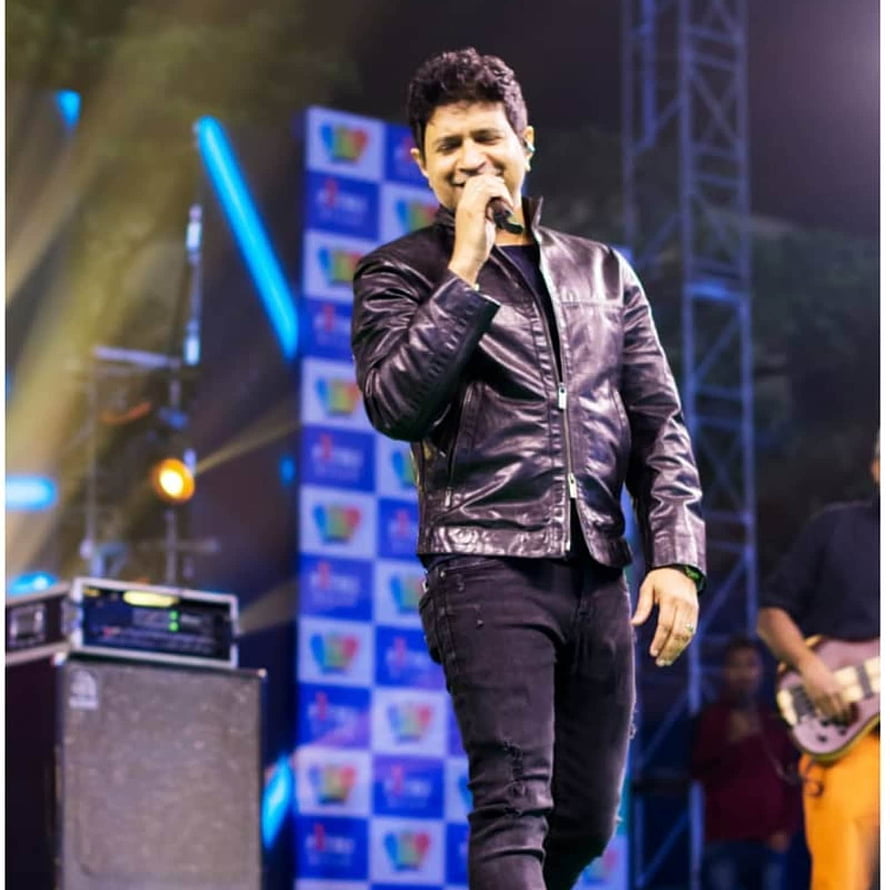 Krishnakumar Kunnath performing live on stage in a black leather jacket HD phone wallpaper