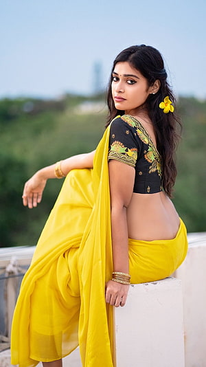 Darshana Gupta in a vibrant yellow saree with black embroidered blouse and floral hair accessory HD phone wallpaper