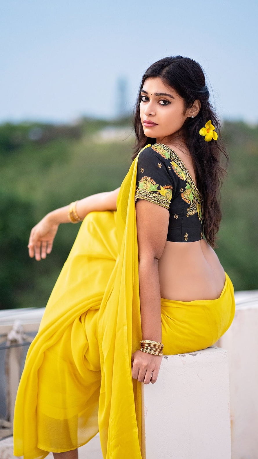 Darshana Gupta in a vibrant yellow saree with black embroidered blouse and floral hair accessory HD phone wallpaper