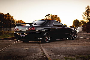 Black Nissan Skyline R34 GTR Rear Three-Quarter View at Golden Hour HD wallpaper