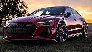 Audi RS7 Sportback in Deep Red Parked on Grass at Sunset HD wallpaper