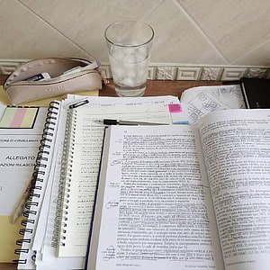 Cozy Law Study Desk Setup With Open Textbook, Spiral Notebook, and Water Glass HD phone wallpaper