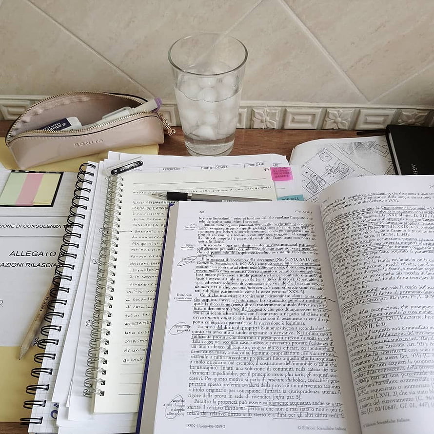 Cozy Law Study Desk Setup With Open Textbook, Spiral Notebook, and Water Glass HD phone wallpaper