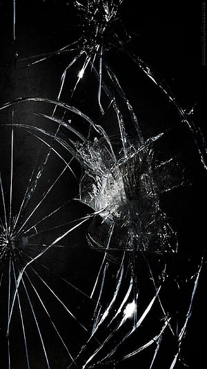 Shattered Glass Texture with Radiating Fracture Lines on Black Background HD phone wallpaper