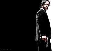 John Wick in a black suit holding a pistol against a high-contrast black and white background HD wallpaper