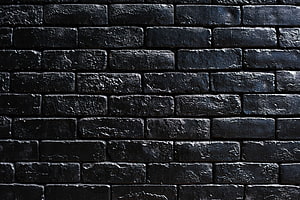 Dark Textured Brick Wall Pattern with Deep Black Tones and Rough Surface Detail HD wallpaper
