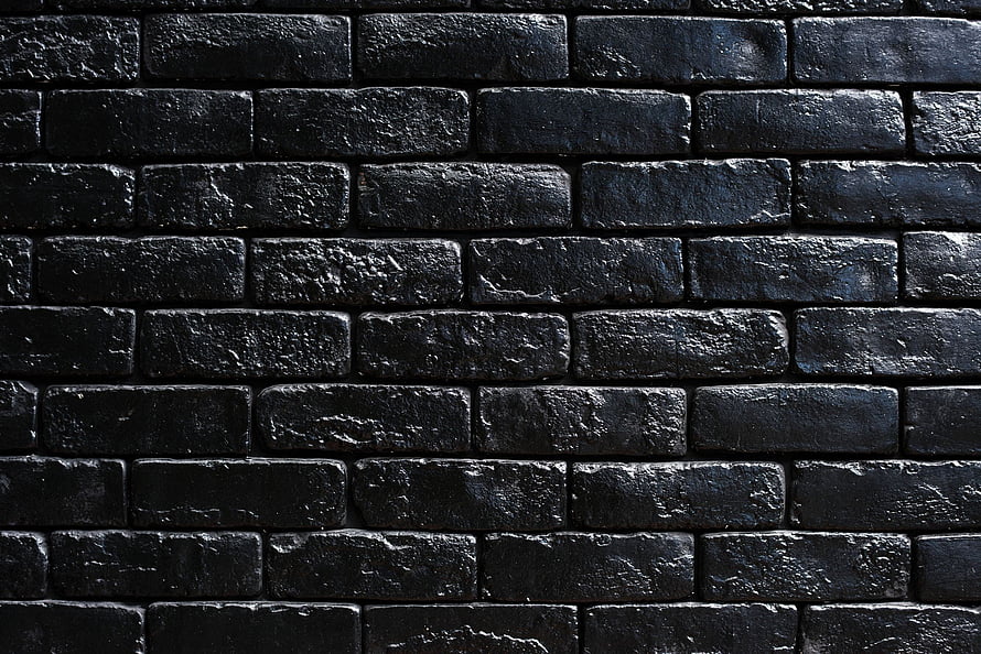 Dark Textured Brick Wall Pattern with Deep Black Tones and Rough Surface Detail HD wallpaper