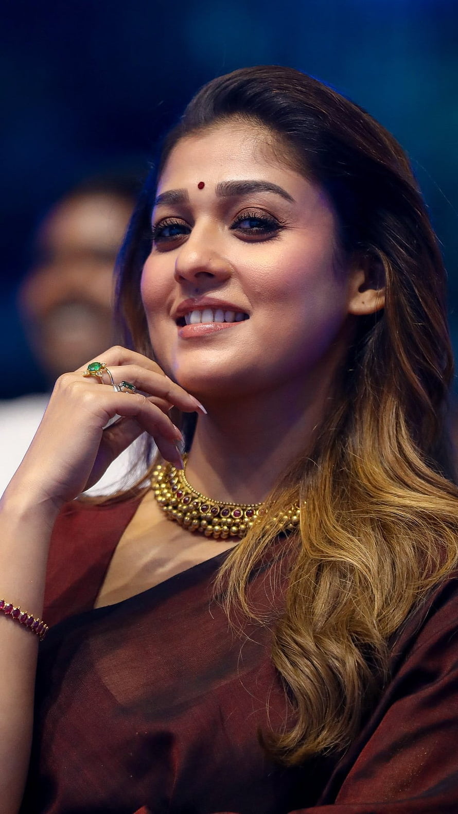 Nayanthara in a maroon saree with traditional gold jewelry and a warm smile HD phone wallpaper
