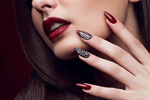 Close-up beauty portrait of a woman with bold red lips and intricate black and red nail art HD wallpaper