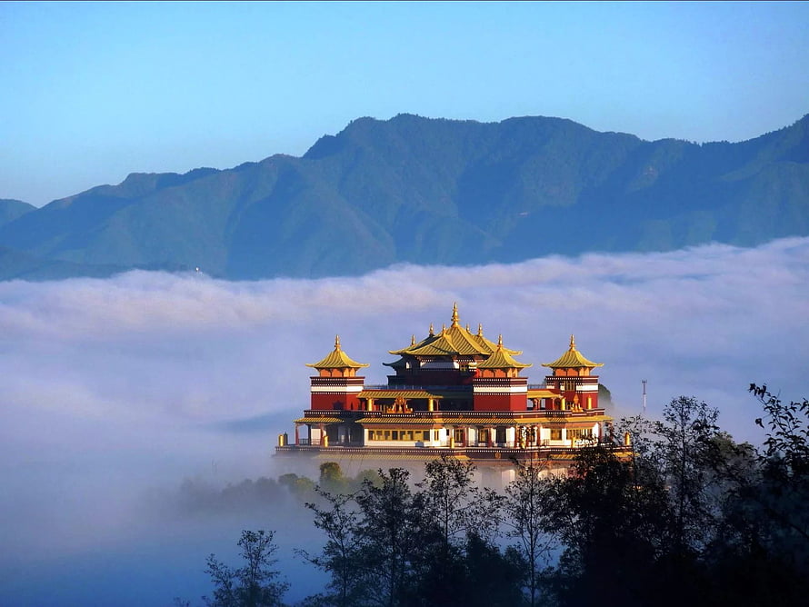 Golden-roofed temple rising above a sea of clouds with misty mountains in Nepal HD wallpaper