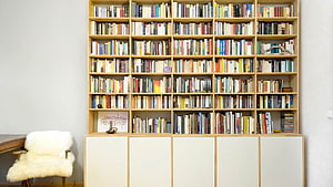 Minimalist Home Library with Floor-to-Ceiling Bookshelves and White Storage Cabinets HD wallpaper