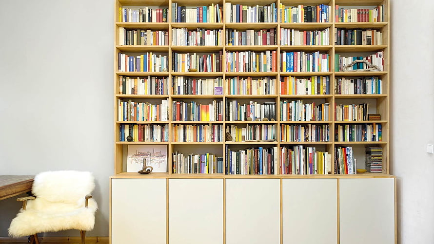 Minimalist Home Library with Floor-to-Ceiling Bookshelves and White Storage Cabinets HD wallpaper