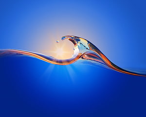 Abstract Water Wave with Golden Sunburst Reflection on Deep Blue Background HD wallpaper