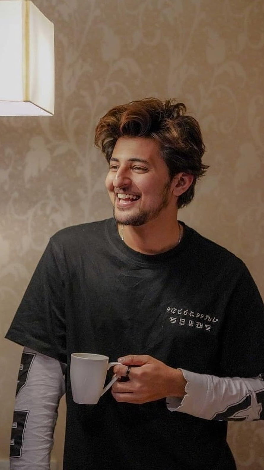 Darshan Raval smiling while holding a white mug in a casual indoor setting HD phone wallpaper