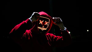 Person in Red Hoodie Wearing Glowing LED Mask with X Eyes and Stitched Mouth HD wallpaper