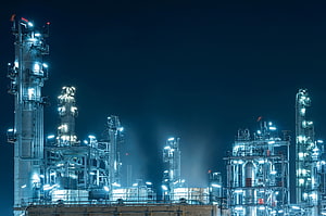 Illuminated Oil Refinery and Petrochemical Plant at Night with Glowing Industrial Towers HD wallpaper