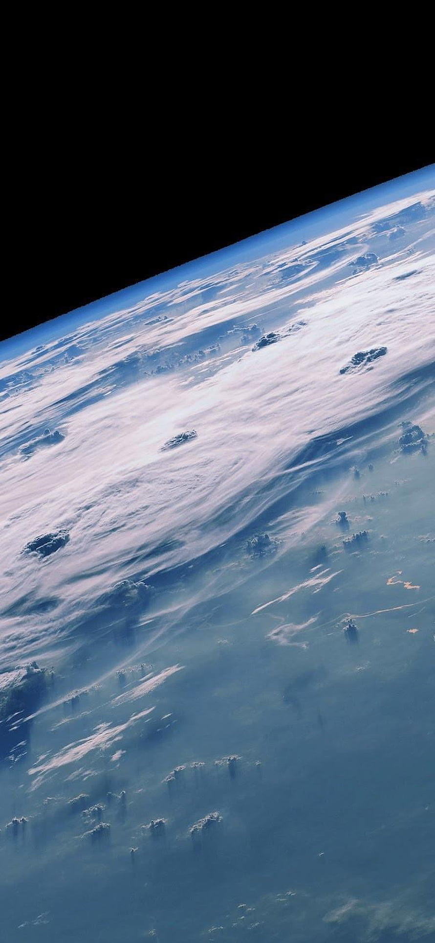 Earth From Space: Swirling Clouds and Atmospheric Glow Over the Horizon HD phone wallpaper