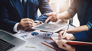 Business Team Analyzing Financial Charts and Data on Tablet in Office Meeting HD wallpaper