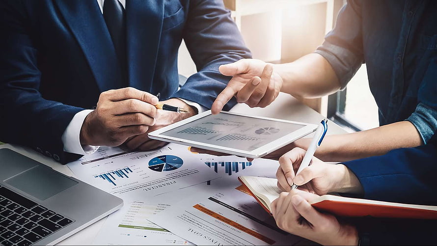 Business Team Analyzing Financial Charts and Data on Tablet in Office Meeting HD wallpaper
