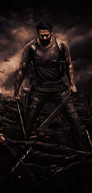 Prabhas as Saaho in Salaar: A Warrior Standing Over a Battlefield of Fallen Soldiers HD phone wallpaper