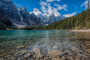 Turquoise Mountain Lake with Snow-Capped Peaks and Dense Evergreen Forest HD wallpaper