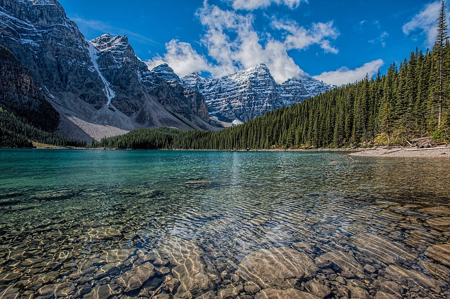Turquoise Mountain Lake with Snow-Capped Peaks and Dense Evergreen Forest HD wallpaper